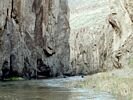 Two kayakers disappearing down the river with vertical walls on both sides