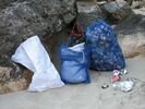 Three bags of river rafting trip garbage leaning against a rock