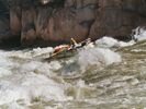 A white whitewater raft running down a steep rapid in the Grand Canyon