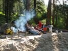 A rafting group sitting in the morning sun beside a campfire at Fawn Creek Camp on the Main Salmon River