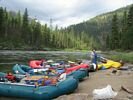 Green, yellow, and red rafts lined up in a row at Jim Moore Camp, Main Salmon River