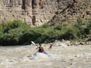 Two girls rowing inflatable kayaks through a small rapid in Desolation Canyon